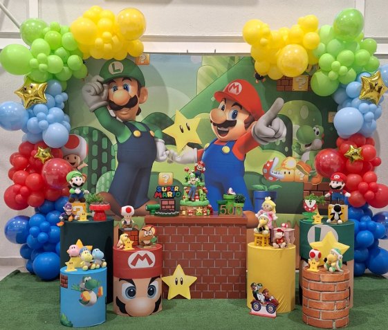 Festa do Super Mario com arcos de balões coloridos, painel de Mario e Luigi e colunas temáticas