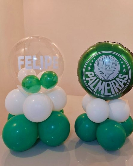 Dois centros de mesa de balões verdes e brancos, um com o nome Felipe e outro com o escudo do Palmeiras